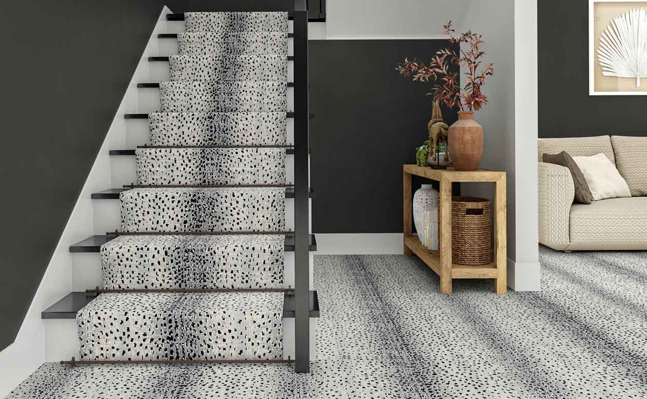 modern entryway with styled wood entry table, staircase and gray walls, gray animal print carpet