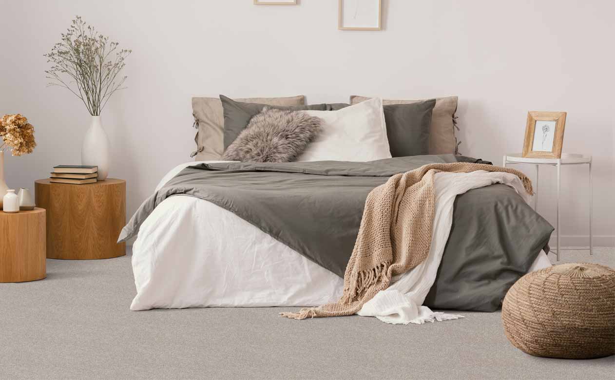 boho bedroom with wood accents, layered textures and plush gray carpet